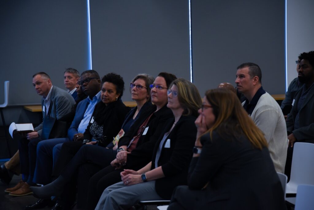 An audience listens to a speaker intently.